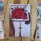 Photo of a small magazine reading 'City Limits: Issue 10' written in red, graffiti style letters pasted over a photo of an old backlit sign. The book is laying on natural wood planks with collage graffiti photos on either side.