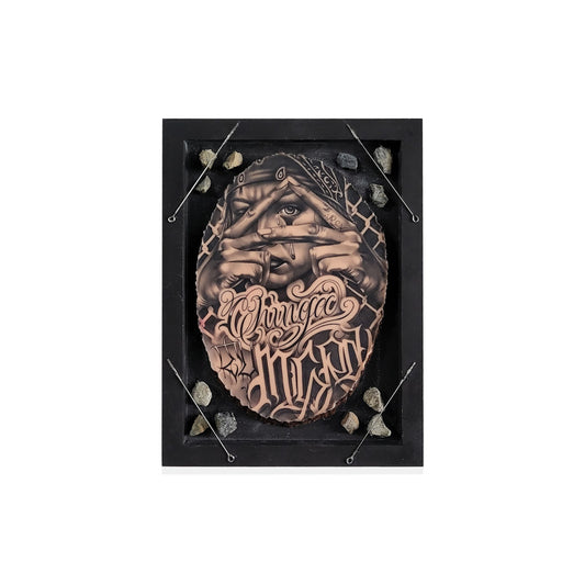 Framed mixed media art featuring a slab of artificial skin tattood of a woman and graffiti style lettering.
