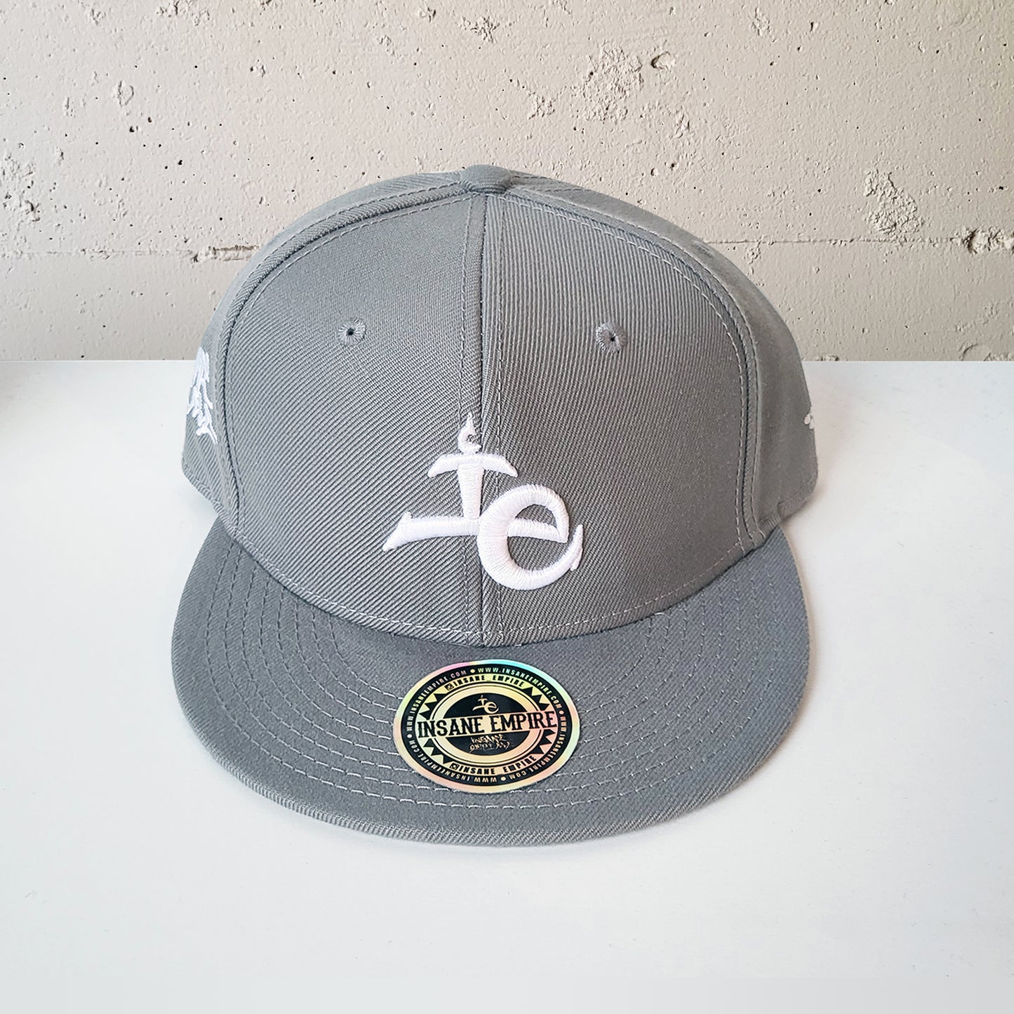 Local artist clothing brand inland empire grey and white snap back