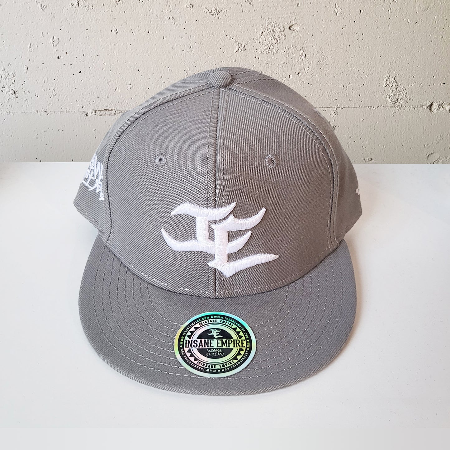 Local artist clothing brand inland empire grey and white snap back uppercase