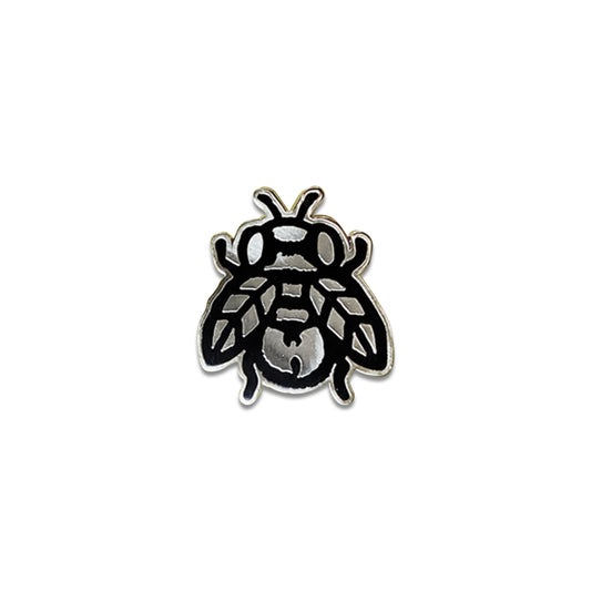 Metallic bee-shaped pin on a white background.