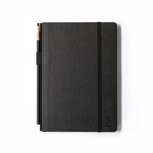 black sketch book with black graphite pencil and pencil holder