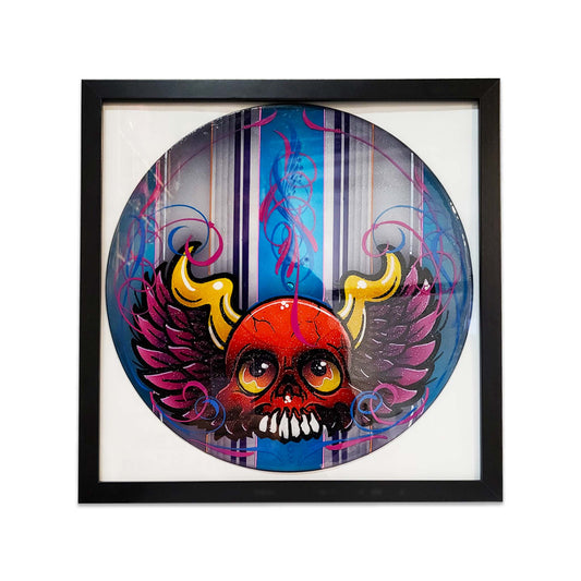 Framed artwork of a colorful skull with wings and classic car pinstriping.