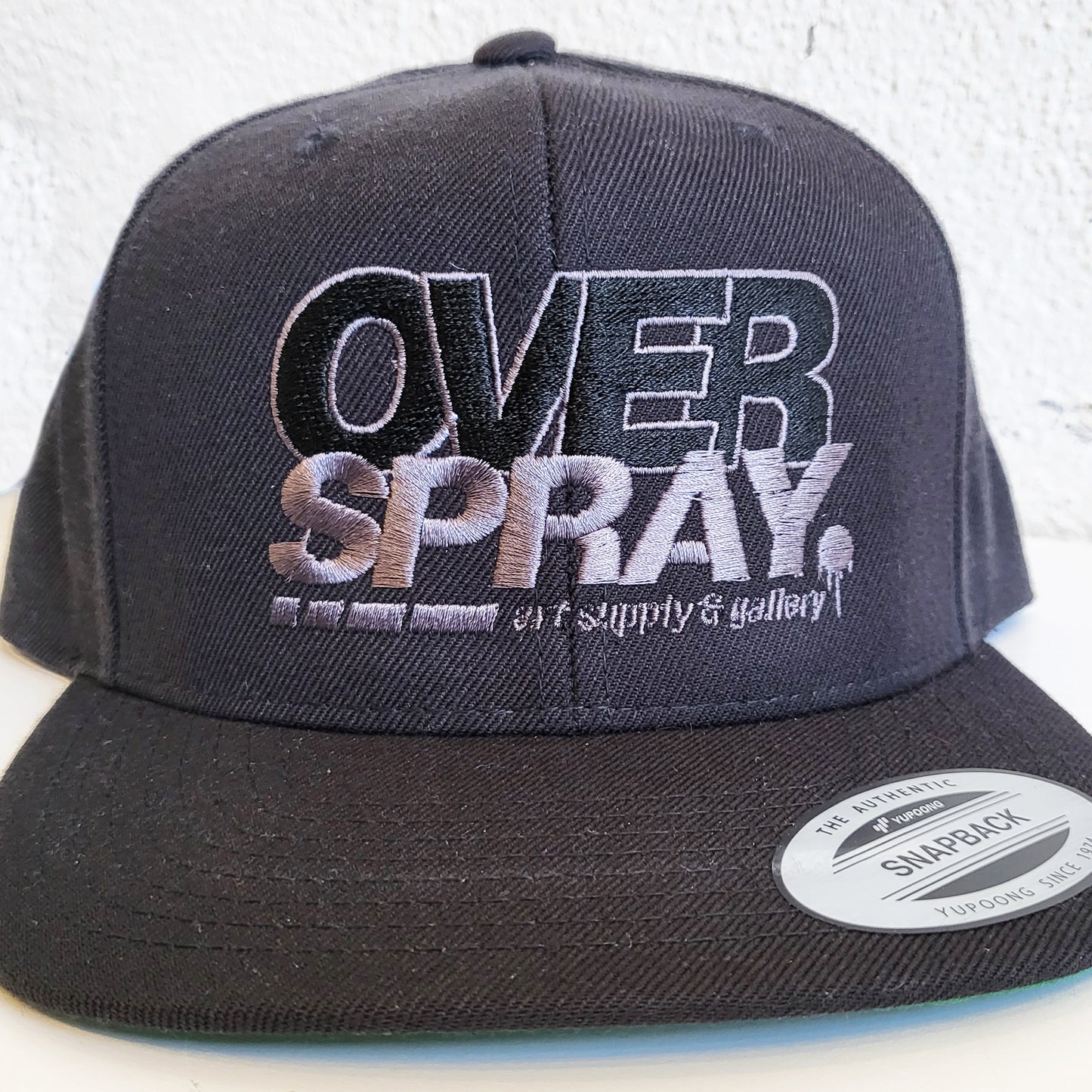Overspray Art and graffiti supply store branded hat in grey and black.