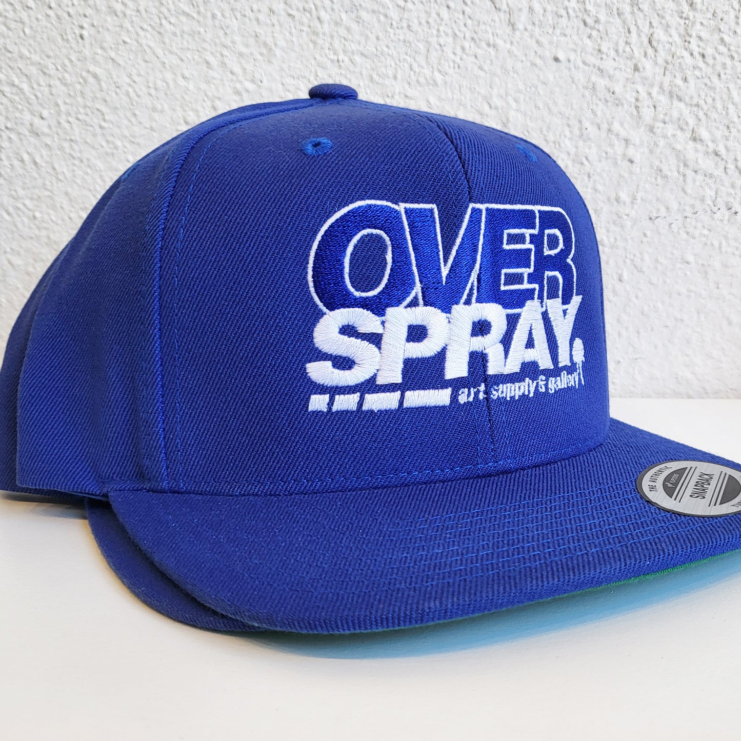 Overspray graffiti supply store brand dodger blue hat side.