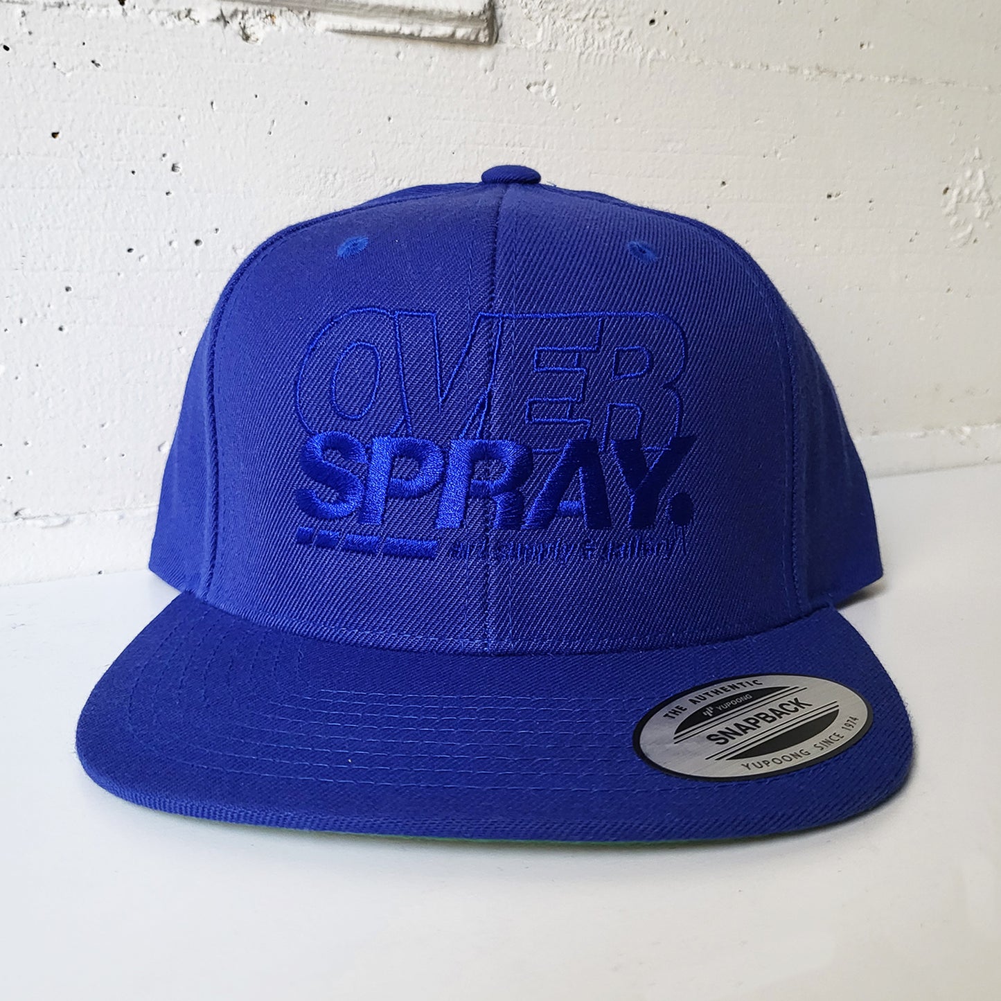 Overspray graffiti shop branded snap back hat in dodger blue on blue.