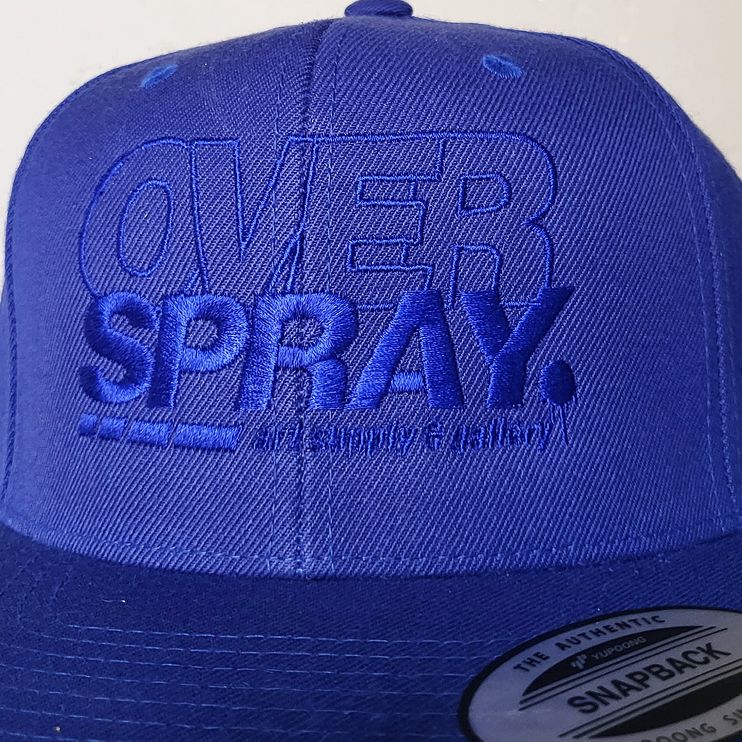 Overspray graffiti shop branded snap back hat in blue on blue detail..