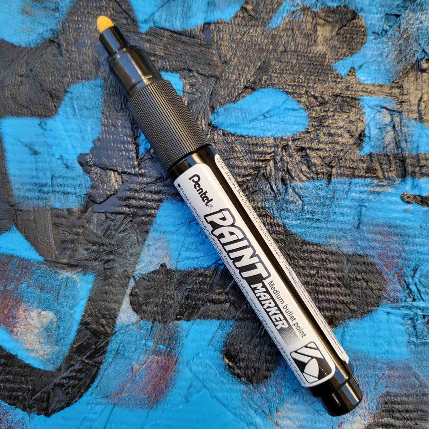 Pentel bullet point paint marker in white on a colored background