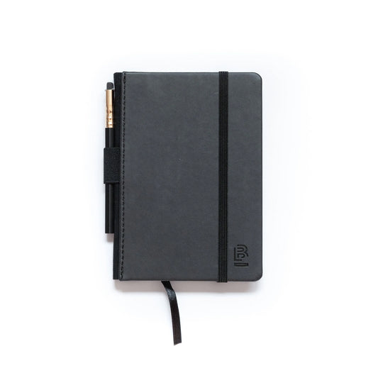 small black sketch book with a black graphite pencil ,pencil holder, and black ribbon divider