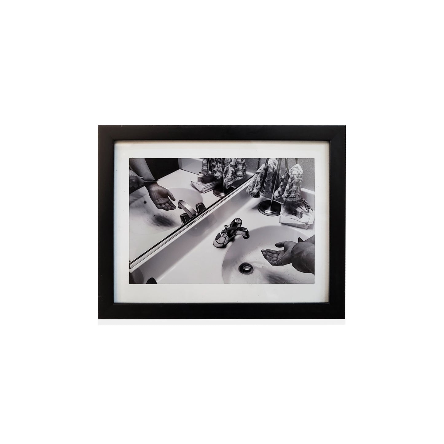 Black framed black and white photo of a bathroom.