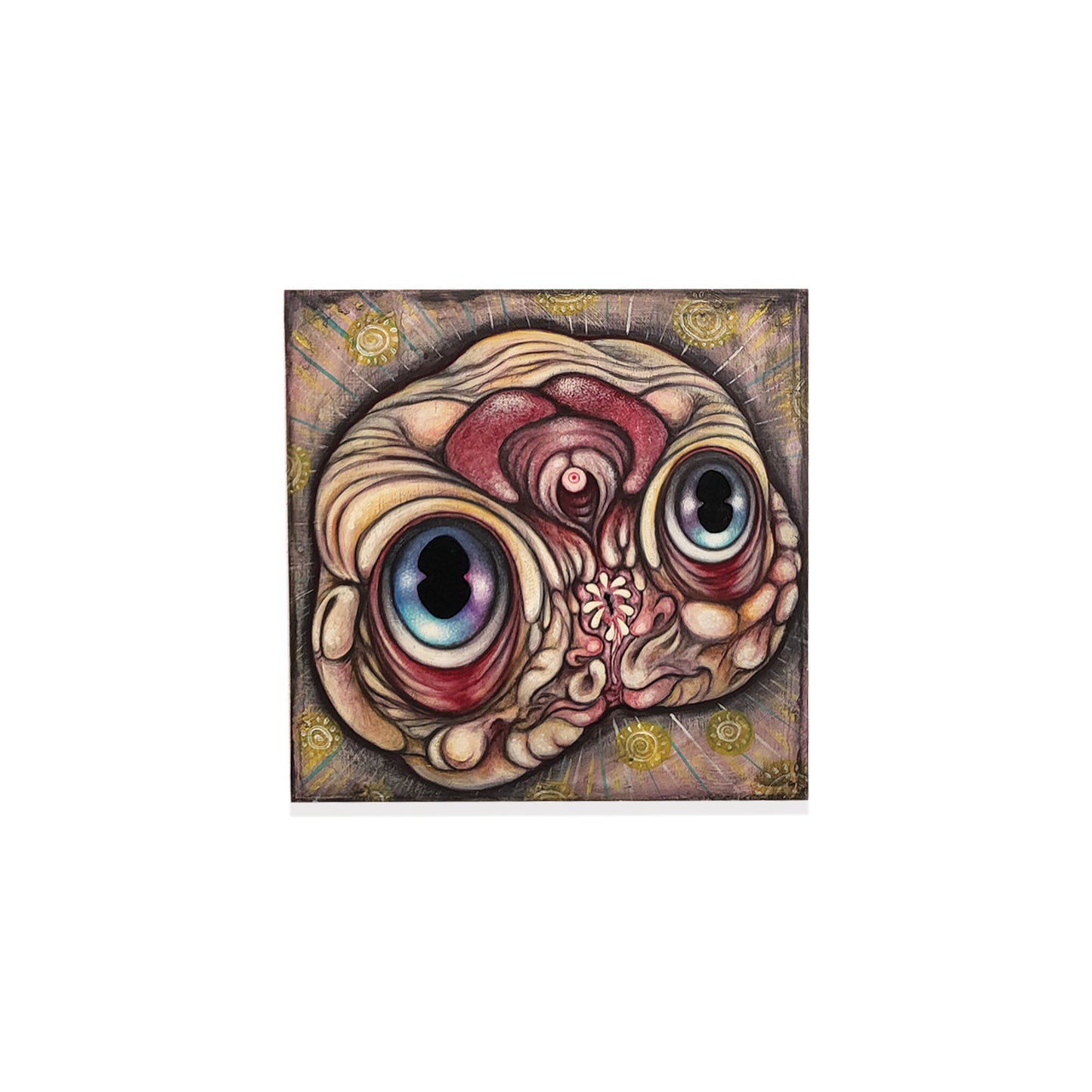 Decorative wall art with a stylized face design on a white background.