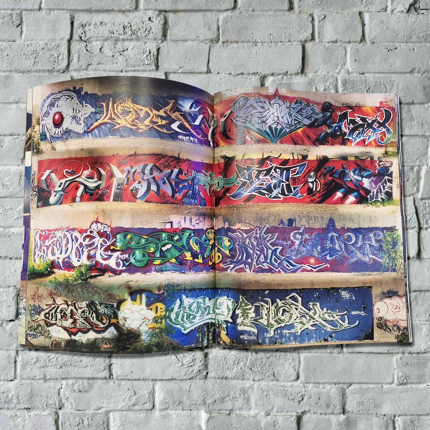 An open magazine with pictures of graffiti on walls.