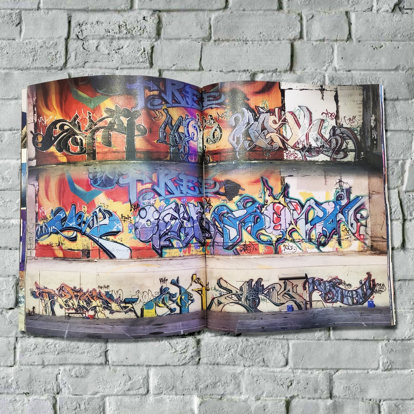 An open magazine with pictures of graffiti on walls.