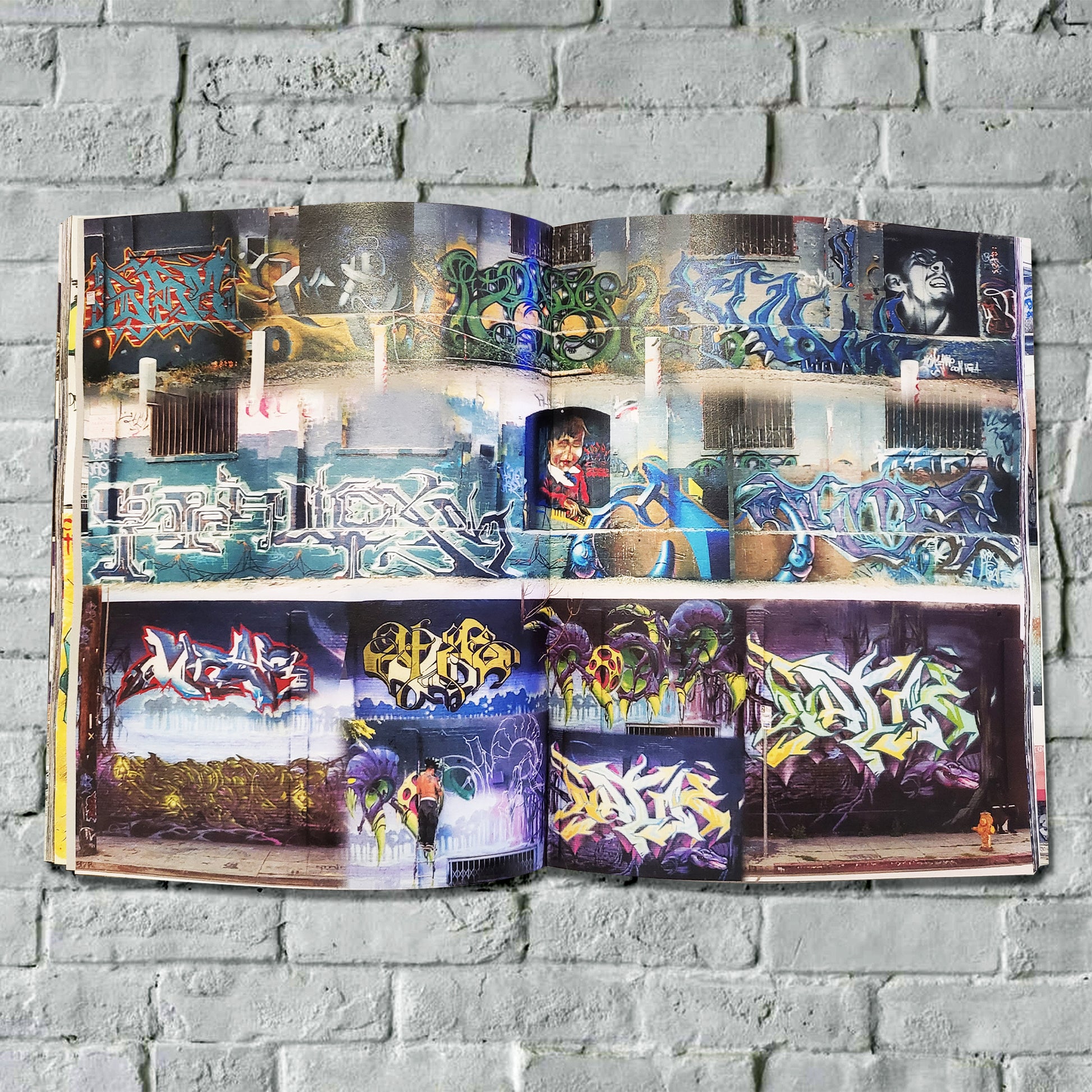 An open magazine with pictures of graffiti on walls.