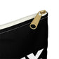 The corner of a black, fabric, pencil bag, zoomed in on the gold zipper with white track
