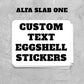 Stack of custom text eggsell stickers with 'Alfa Slab One' text on a gray textured background.