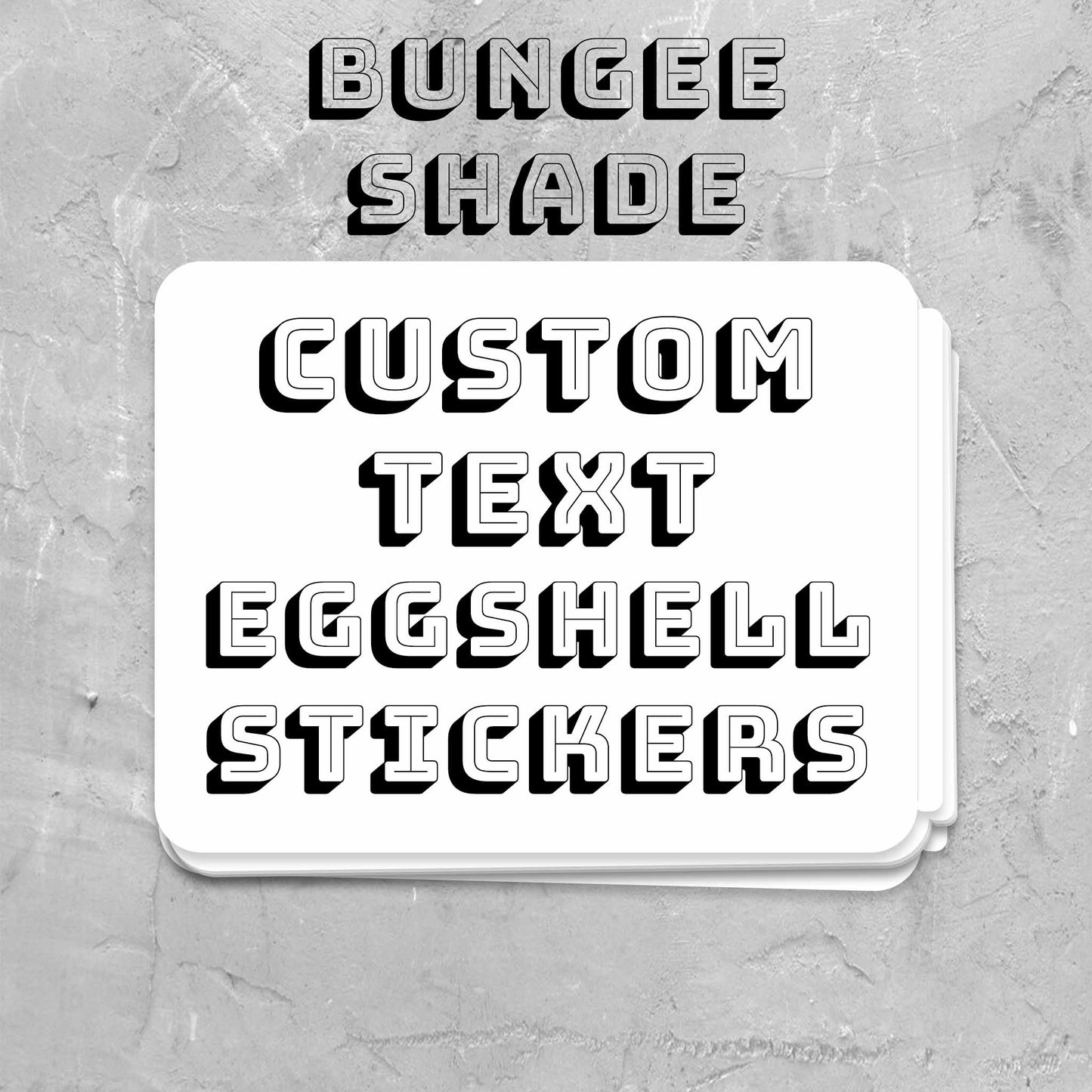 A stack of white custom text eggshell stickers with black 3D lettering, with the text 'BUNGEE SHADE' and 'CUSTOM TEXT EGGSHELL STICKERS' above it.