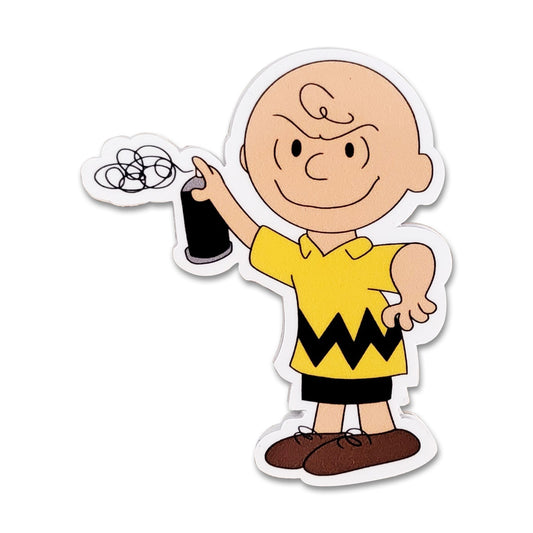 A die-cut vinyl sticker of Charlie Brown holding a black spray paint can. Depicted in his classic yellow and black shirt, with brown shorts and shoes, on a solid white background.