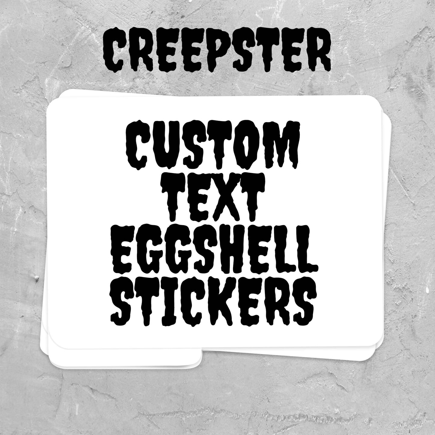 A stack of white custom text stickers with black distressed font reading 'CREEPSTER' and 'CUSTOM TEXT EGGSHELL STICKERS' on a gray textured background.