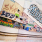 Photoof a warehouse exterior wall with numerous graffiti style paintings.