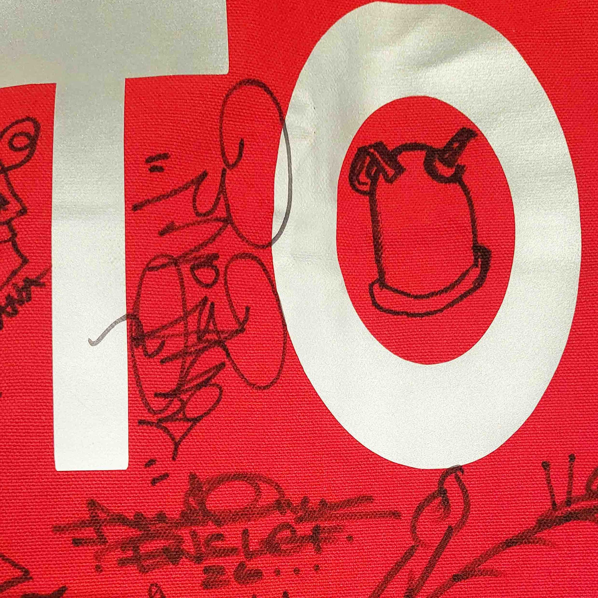 Red and white graphic with black line graffiti art and signatures on a red bag.