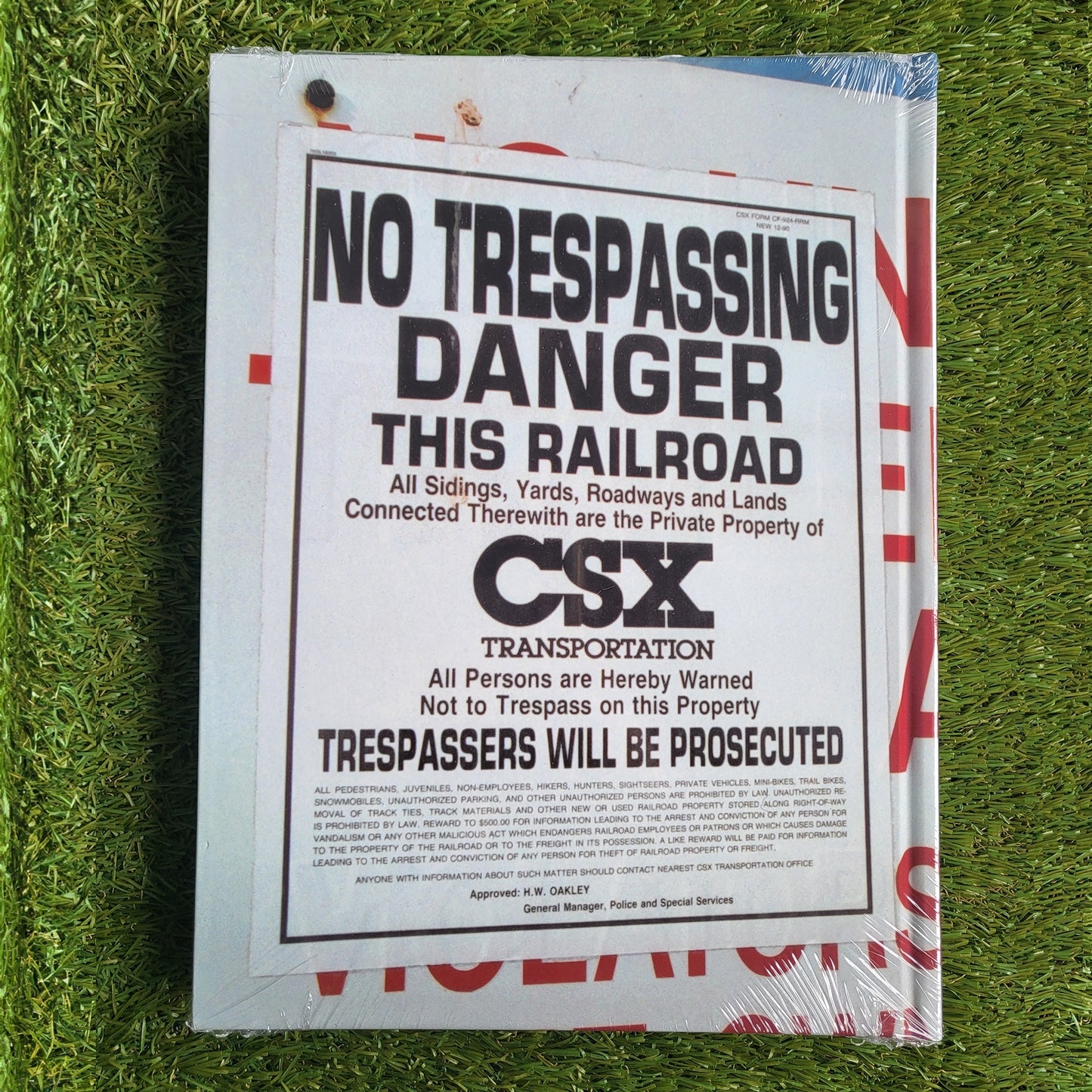 Back of a hardcover book, shows a photo of a 'No Trespassing' sign on the cover with a grass background