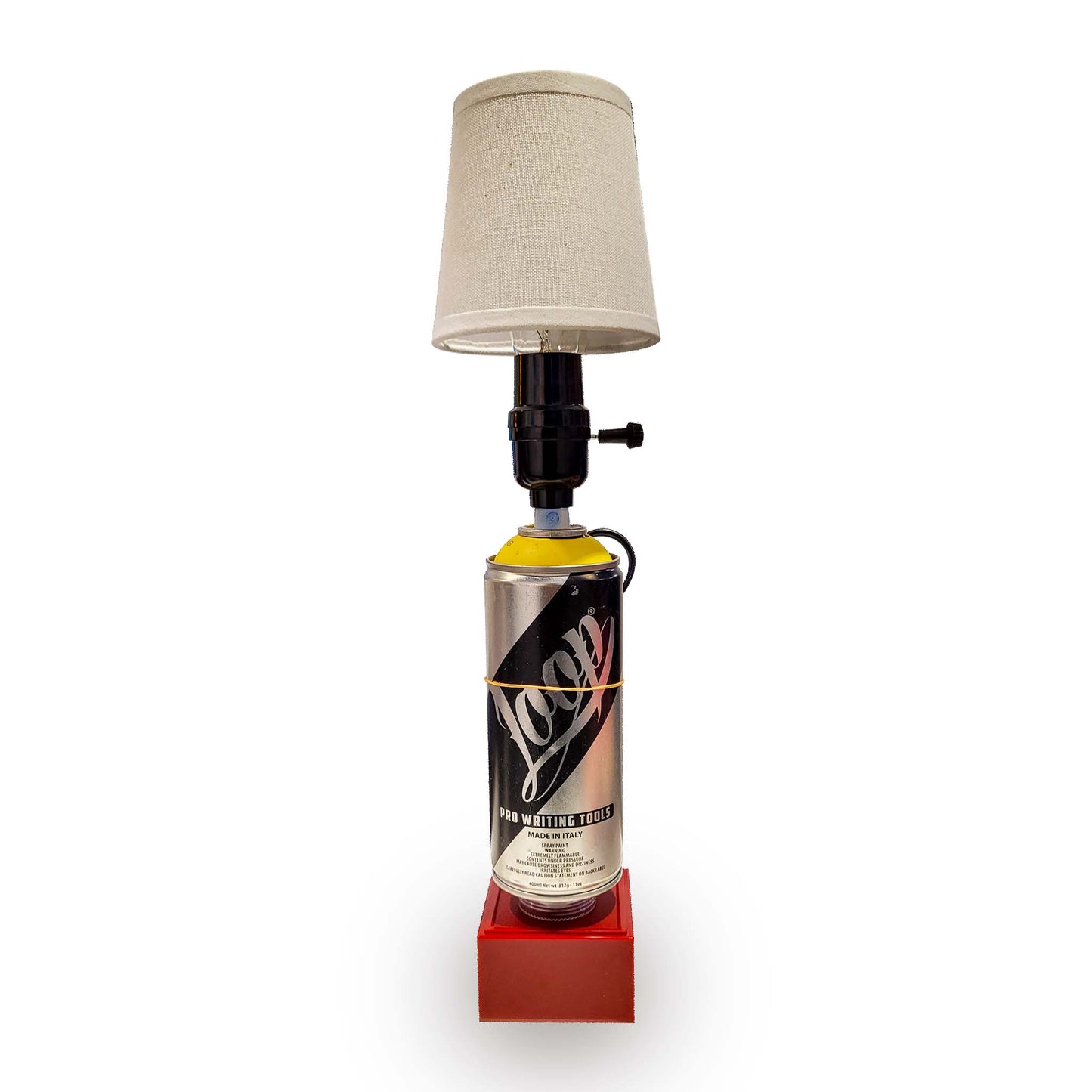 Lamp made from a Loop spray paint can with a beige lampshade on a white background