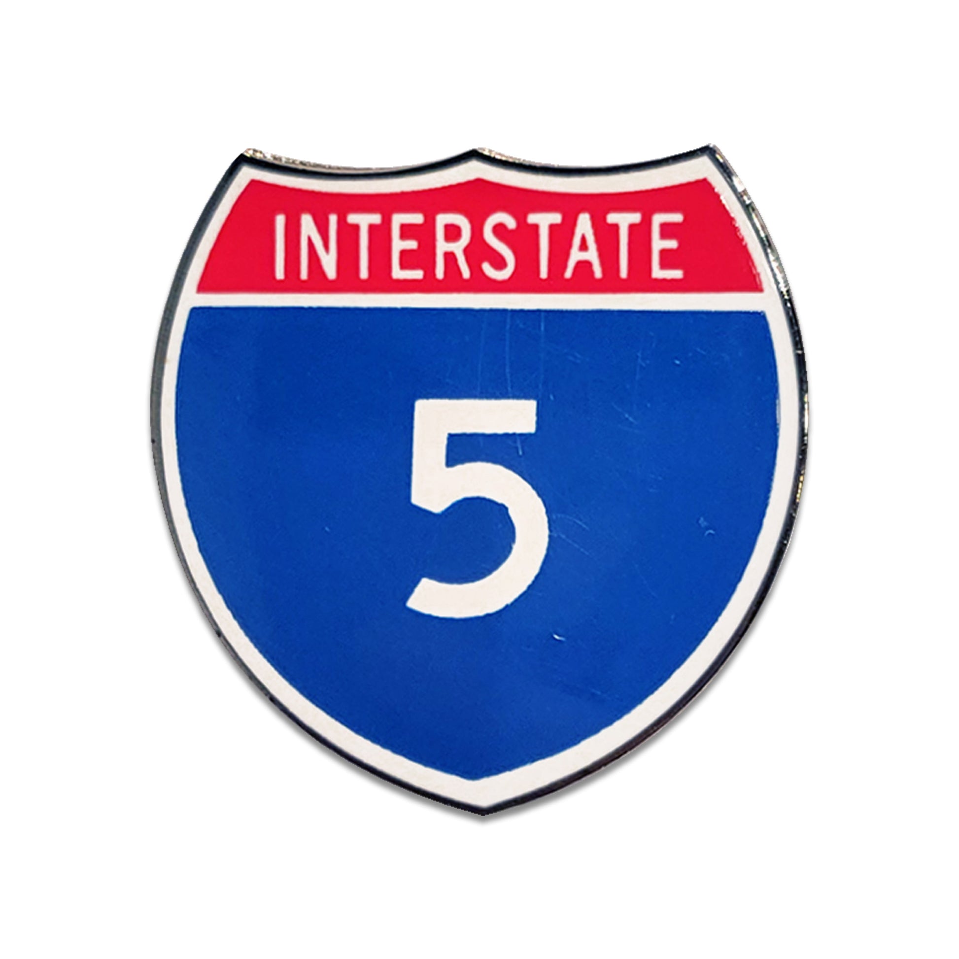 Shiny enamel pin shaped like an interstate highway shield with 'INTERSTATE 5' on a white background.