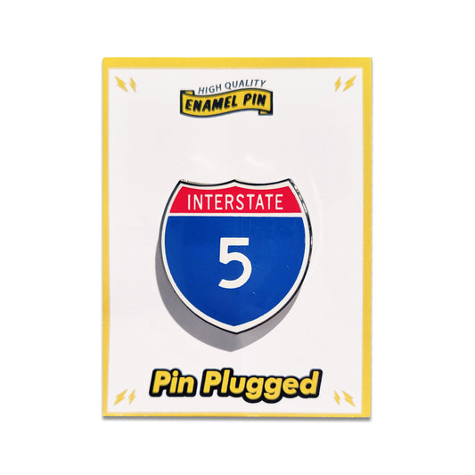 Enamel pin of an interstate 5 sign on a white card with 'Pin Plugged' branding.