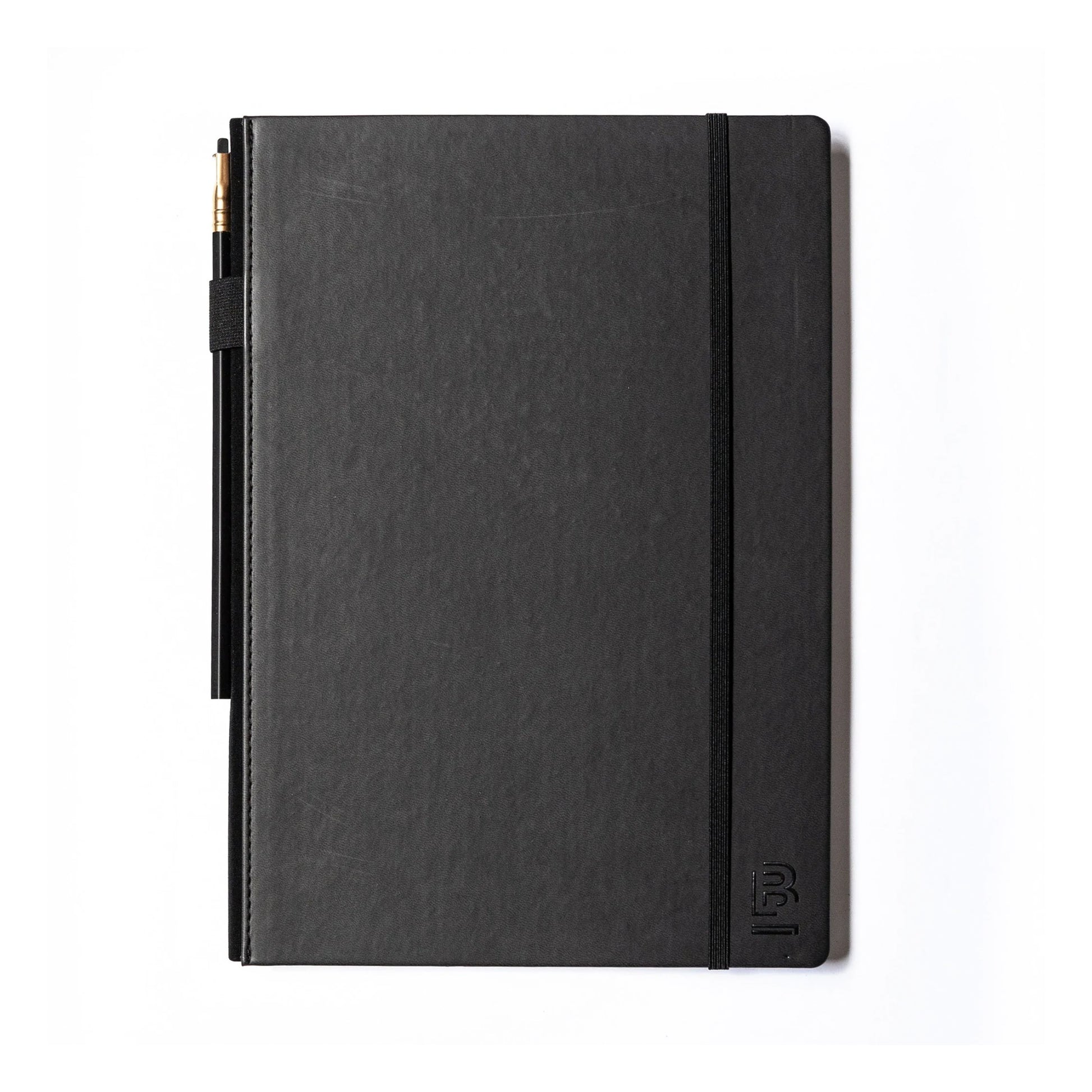 black sketch book with a black graphite pencil and pencil holder lying on a white background