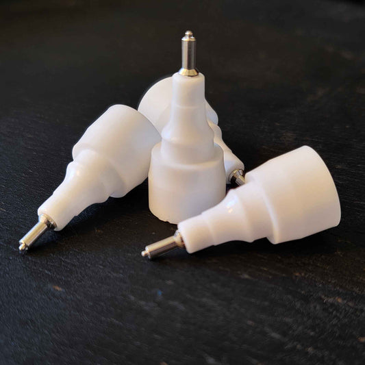 Four white metal pen tips on black background