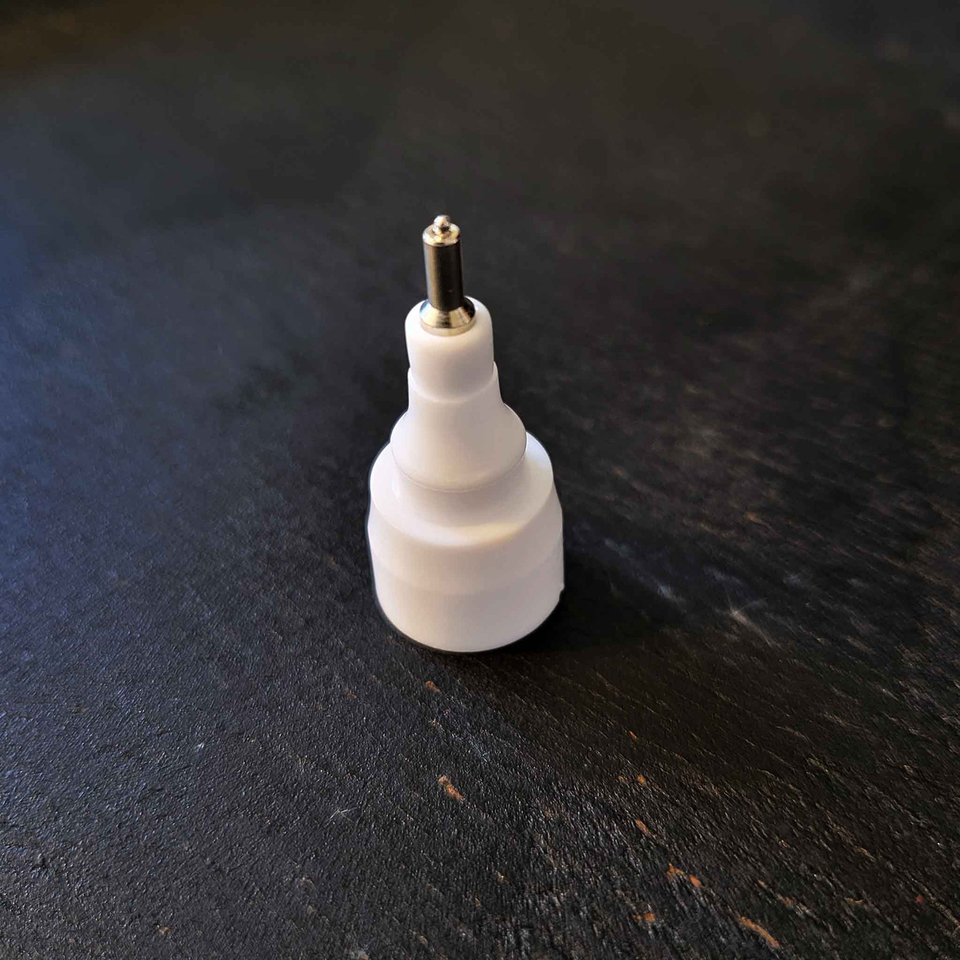 One white plastic and metal pen tip on black background