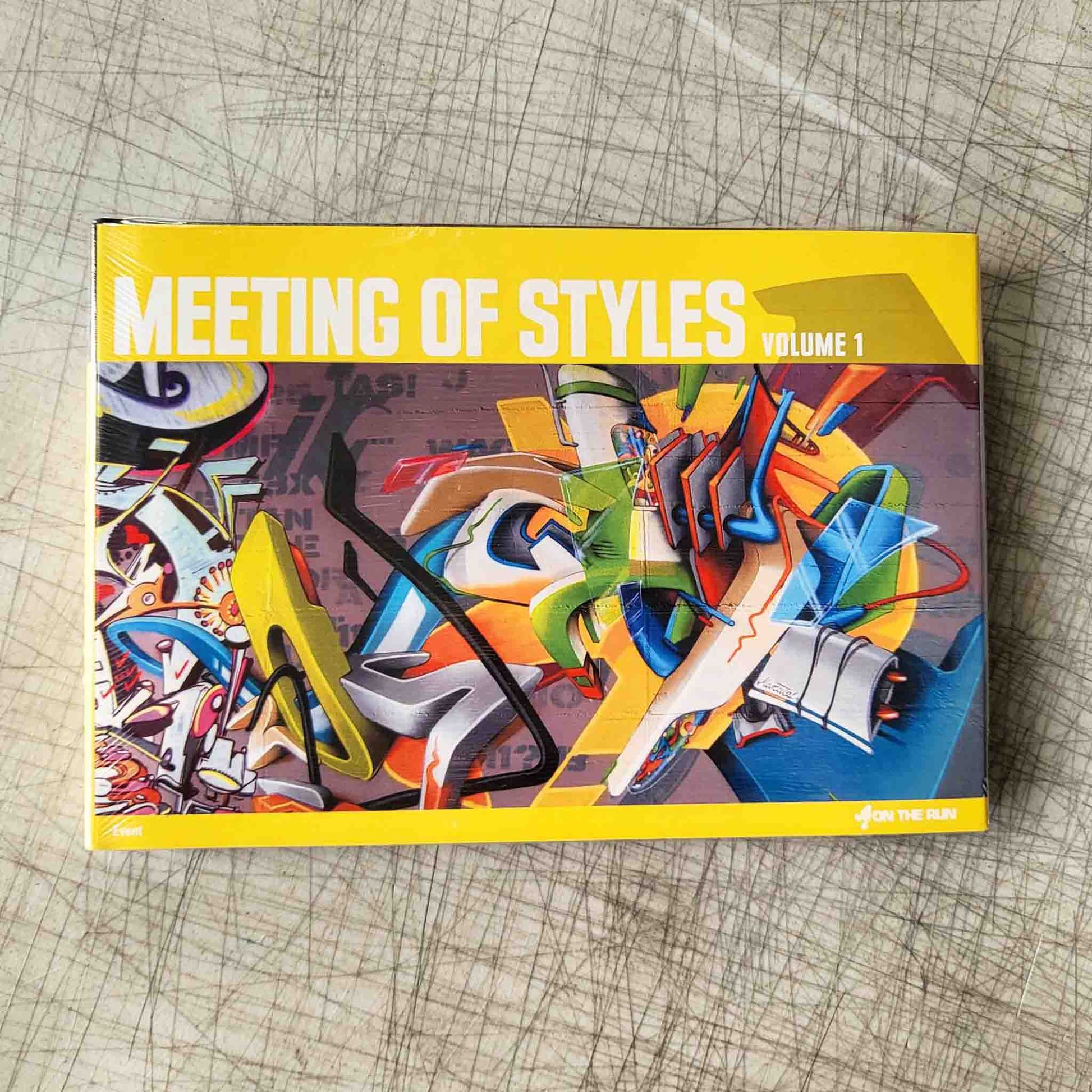 Book titled 'Meeting of Styles Volume 1' with colorful abstract design on a textured surface
