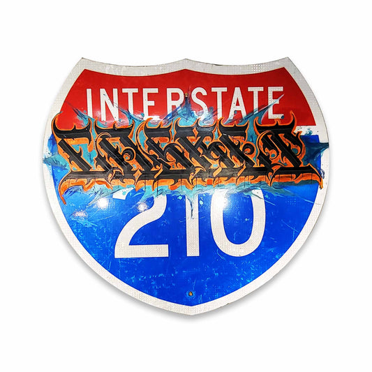 Decorative sign resembling an interstate highway sign with 'Interstate 210' text and stylized lettering.