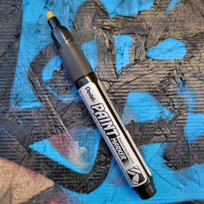 Pentel bullet point paint marker in silver on a colored background