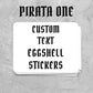A stack of white custom eggshell stickers with black gothic-style text reading 'PIRATA ONE' and 'CUSTOM TEXT EGGSHELL STICKERS'.