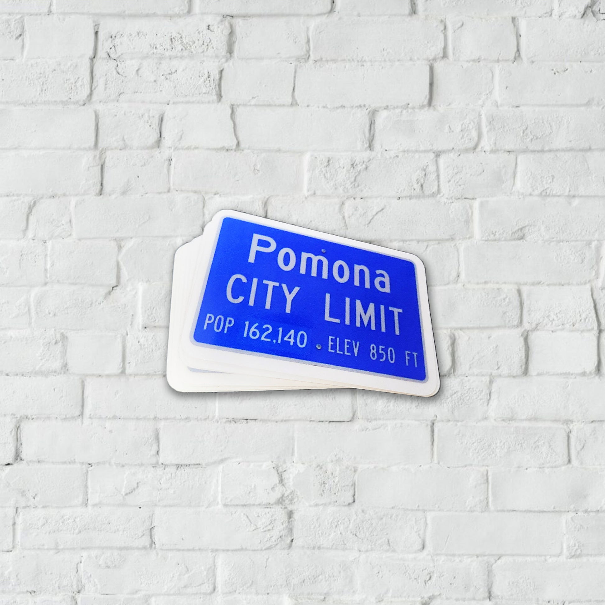 White and blue sticker of a Pomona City Limit traffic sign.