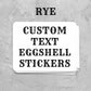 A stack of white rectangular stickers with black decorative text reading 'CUSTOM TEXT EGGSHELL STICKERS' and the word 'RYE' appears in black serif font, suggesting a customizable product listing.