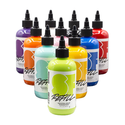 10 clear bottles of paint/ink with tapered lids. Bottles are in the shape of a triangle with the top point  aimed towards to viewer. Colors include: purple, white, black, red, orange, pink, blue, aqua, yellow and neon green.