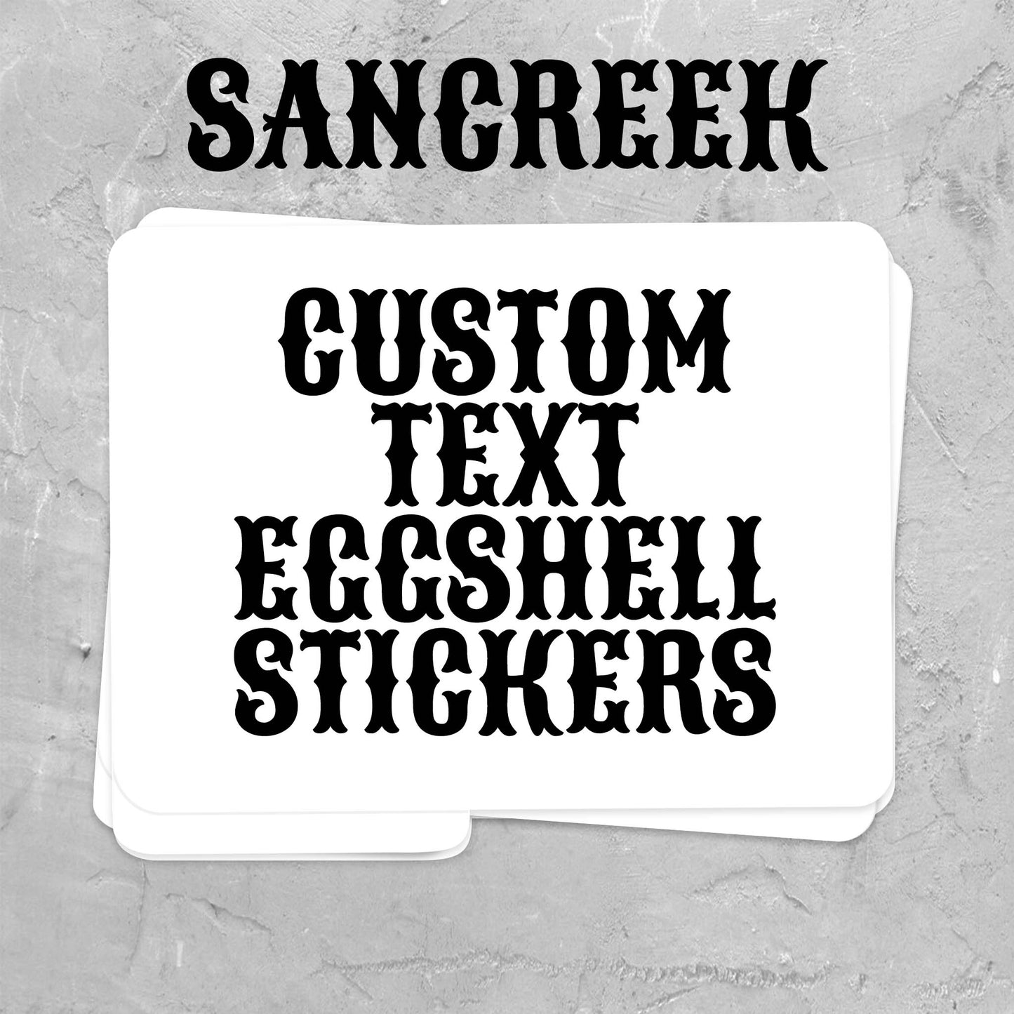 A stack of white custom eggshell stickers with black gothic-style text reading 'SANCREEK' and 'CUSTOM TEXT EGSHELL STICKERS' on a textured gray background.