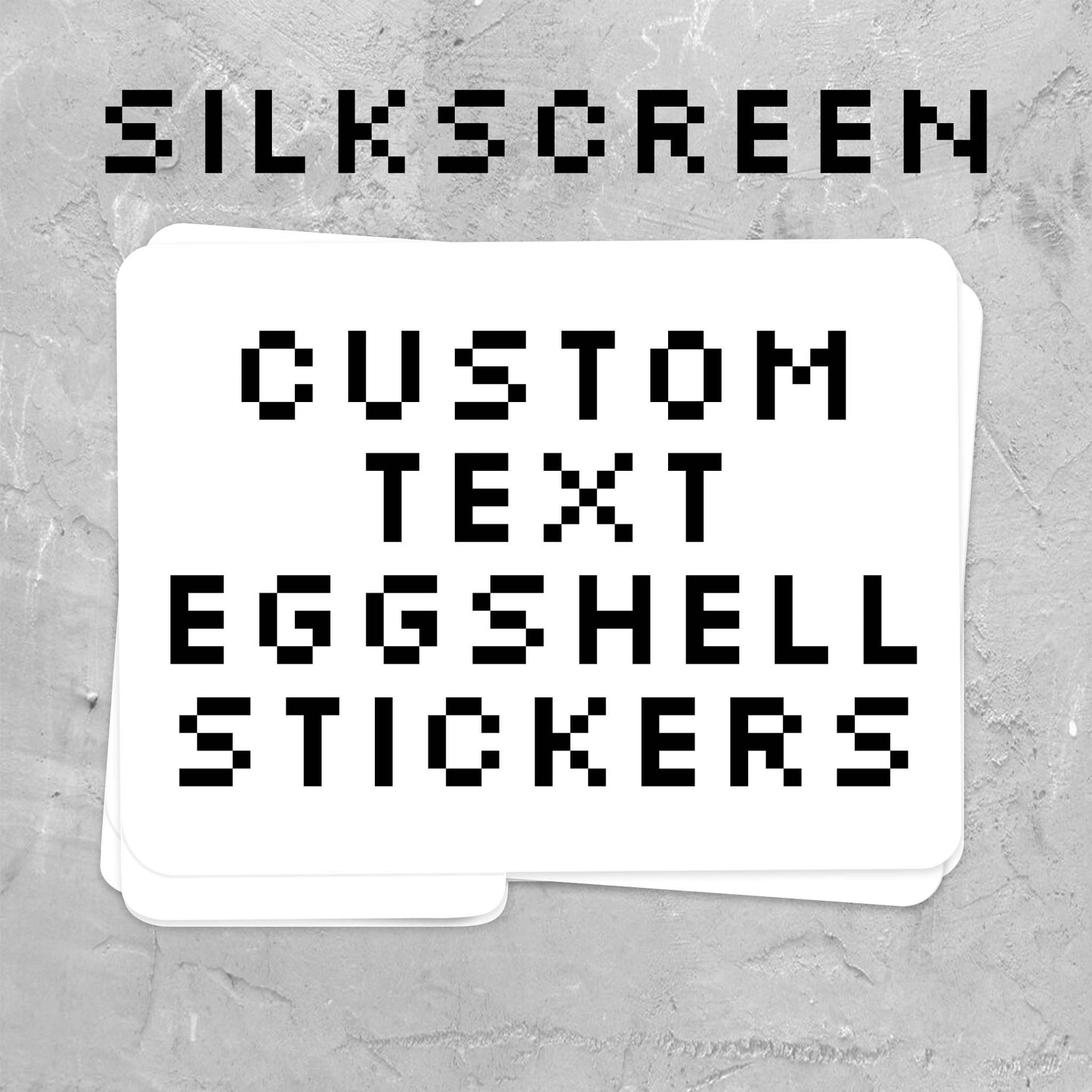 A stack of white custom text eggshell stickers with black pixel-style lettering, shown on a textured gray background with the words 'SILKSCREEN' above.