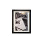 Black framed black and white photo of a notebook with writing and a pen.