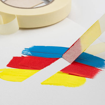 An example of using masking tape with a piece of tape being lifted from a page with yellow, red and blue paint overlaid it.