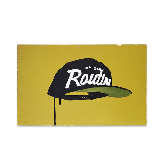 A green yellow painted board with a black hat that reads in white "My Daily Routine".