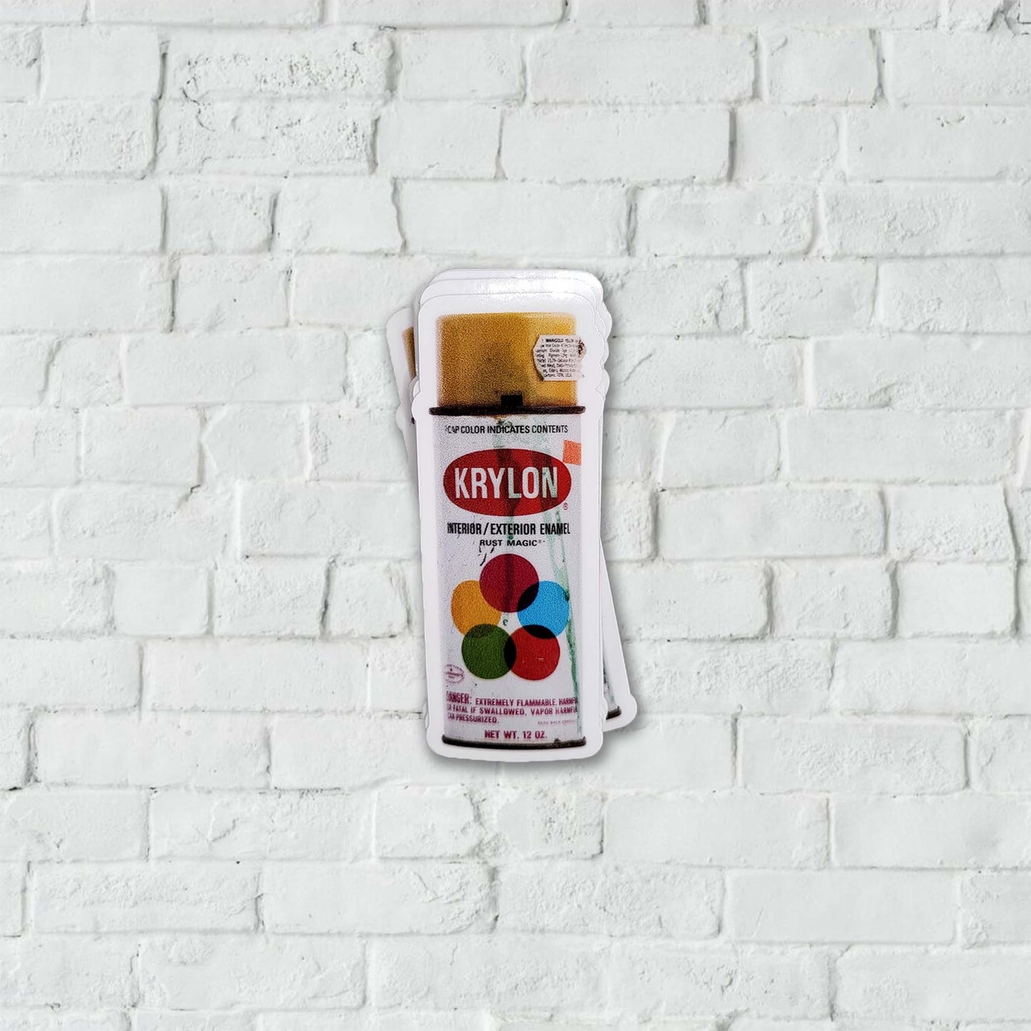 Krylon spray paint can sticker on a white brick wall background.