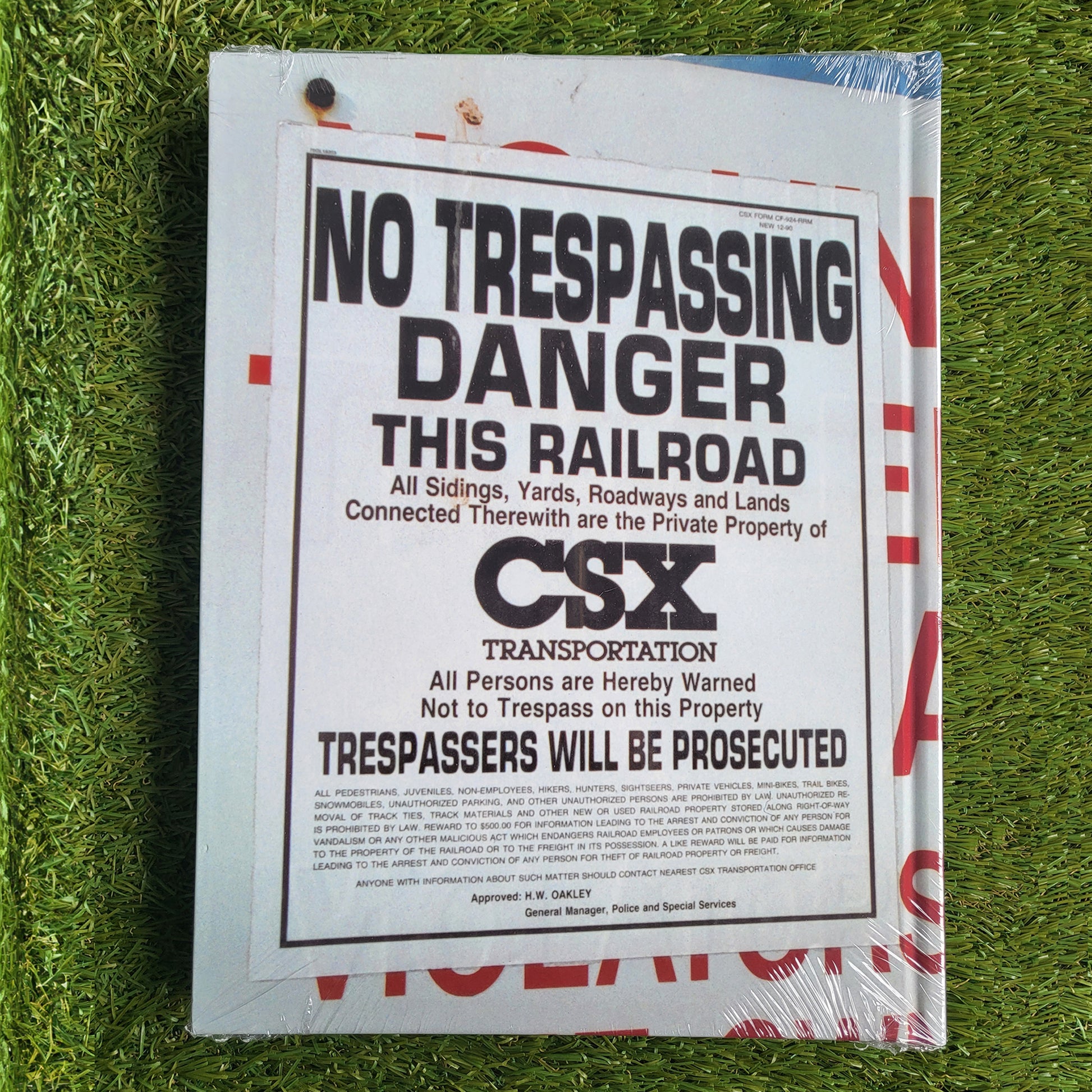 Back of a hardcover book, shows a photo of a 'No Trespassing' sign on the cover with a grass background