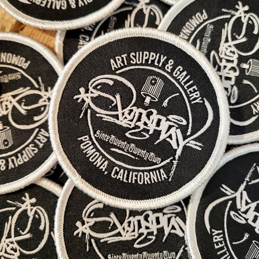 round black overspray tag patch with a silver edge
