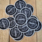 round black overspray tag patch with a silver edge