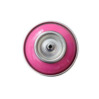The top of a spray paint can, with a bright pink color swatch in the middle of the silver, metal rings of the can.